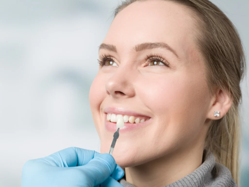 patient smiling while receiving a color-matched porcelain veneer in Knoxville, TN